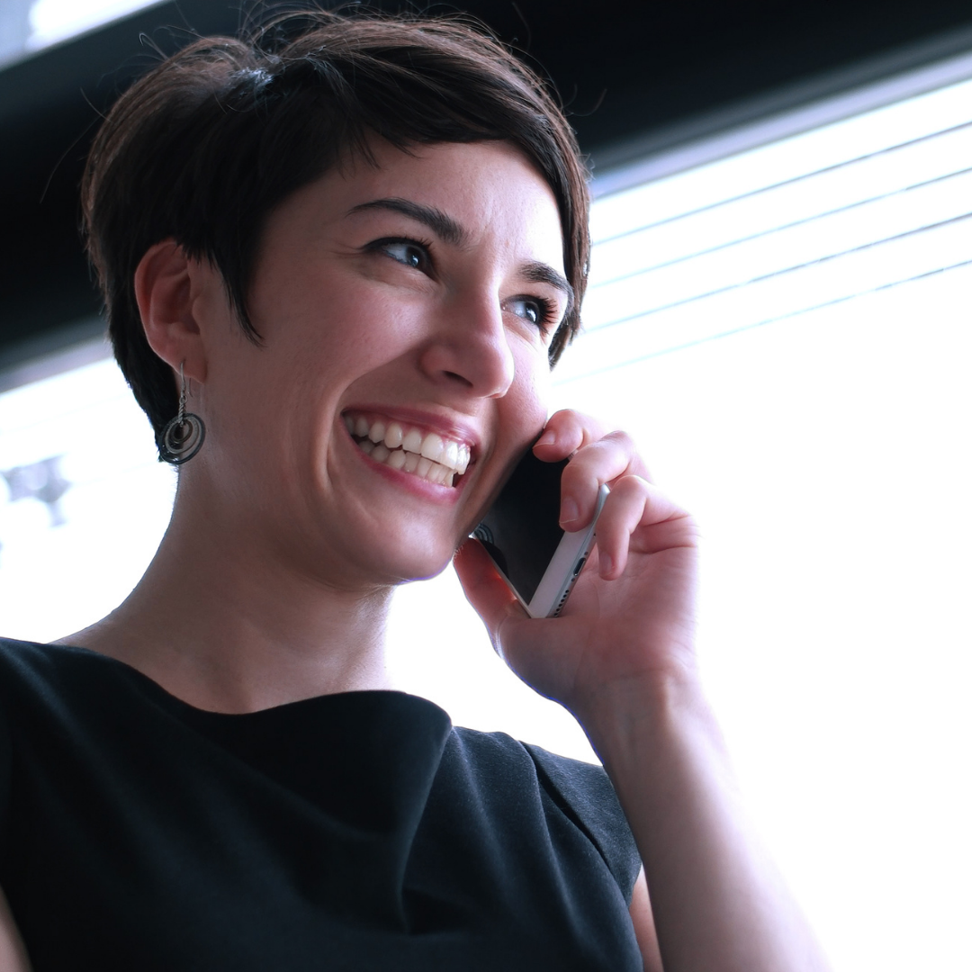 young woman smiling while on her mobile phone